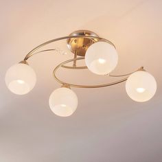 a ceiling light with three white globes hanging from it's center and two circular lights on each side