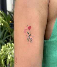 a woman with a flower tattoo on her left arm and the word love written in it