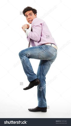 a man in jeans and a pink shirt is posing for the camera with his hands on his hips