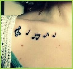 a woman's shoulder with musical notes on it