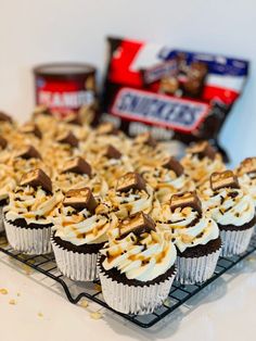 cupcakes with white frosting and chocolate toppings are on a cooling rack