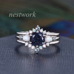 a blue and white diamond ring sitting on top of a black surface with the words network above it