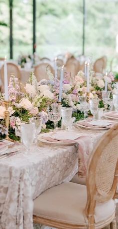 the table is set with white and pink flowers