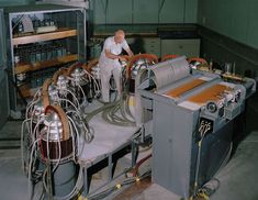 a man working in a machine shop with lots of wires on the conveyor belt