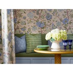 a table with blue and white vases sitting on top of it next to a green couch