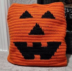 a crocheted pumpkin pillow sitting on top of a counter