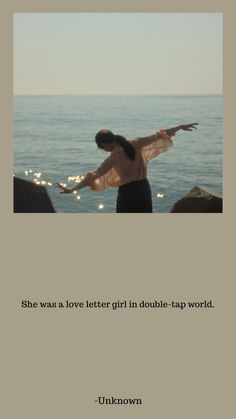 a woman standing on top of a beach next to the ocean with her arms outstretched