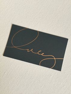 a black and gold business card with the word queen written in cursive writing