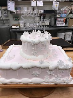 a white frosted cake sitting on top of a wooden table