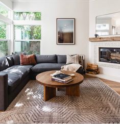 a living room with a couch, coffee table and fire place in the center area