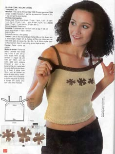 a woman is wearing a knitted top and posing for the camera with her hand on her hip