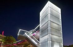 a tall white building with lights on it's sides and stairs leading up to the top