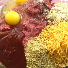 an assortment of ingredients in a bowl for making meatballs and cheeses on a table