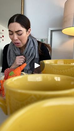 a woman is looking at some yellow dishes