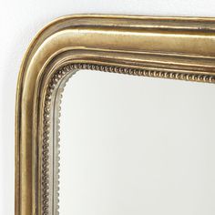 an ornate gold framed mirror against a white wall