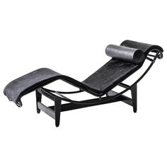 a black chaise lounge chair with an ottoman on it's back and foot rest