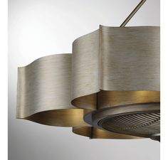 a modern chandelier hanging from the ceiling with two shades of beige fabric on it