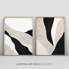 two black and white art prints hanging on a wall next to each other in wooden frames