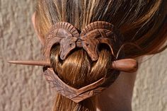 a woman with long hair has two elephants in the shape of a heart on her head