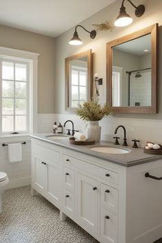 a white bathroom with two sinks and mirrors