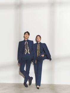 two people in suits and ties standing next to each other with their hands on their hipss