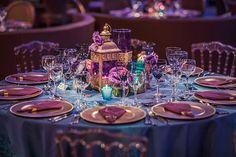 the table is set with purple and gold place settings