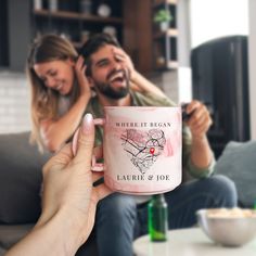 a man and woman sitting on a couch holding a coffee mug