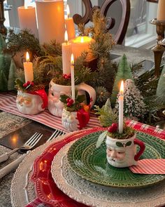 a christmas table setting with candles and plates