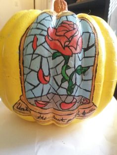 a stained glass pumpkin with a rose on it