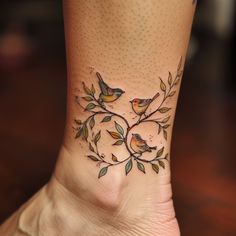 a small tattoo on the ankle of a woman's foot with two birds sitting on it