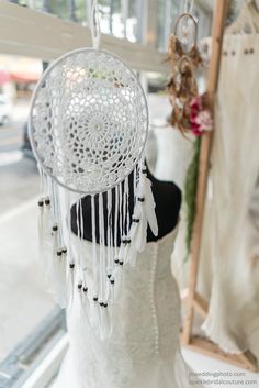 a wedding dress hanging on a rack in front of a window