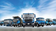 a group of trucks parked next to each other in front of a blue cloudy sky