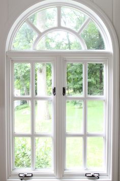 an arched window in a white painted wall