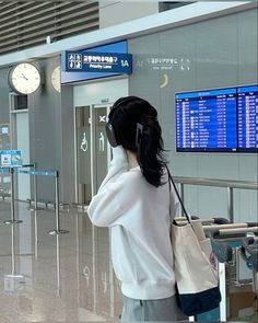 a woman is talking on her cell phone at the airport