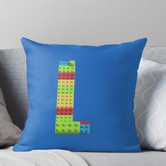 the letter l made out of legos on a blue background throw pillow by pixelpix