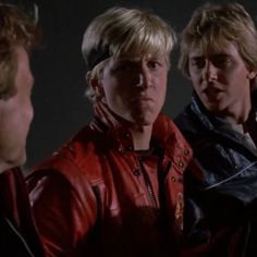 three men in leather jackets are talking to each other