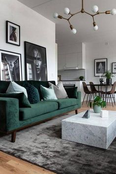 a living room filled with furniture and pictures hanging on the wall above a coffee table