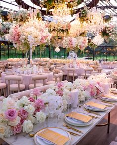 the tables are set up with flowers and place settings for an elegant dinner or reception