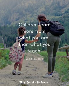 a woman and child walking down a dirt road with the words children learn more from what you are than what you teach