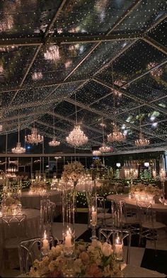 an indoor wedding venue with chandeliers and tables