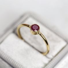 This dark red Ruby Ring in gold is perfectly minimal, modern and feminine. Can be worn alone for ultimate simplicity, or mix, match & stack for a fun, unique look. Featuring a single solitaire ruby bezel set into a simple, smooth 14k Gold Filled band. The Ruby is 4mm, in a round cut, and a rich deep dark raspberry red. This ring is also available as part of a set of either two or fours stacking rings - please see links further below under 'MATCHING ITEMS'. A 'fine jewellery' ring - simple &a Red Ruby Ring, Ruby Anniversary, July Birthstone Ring, Aquamarine Studs, Ruby Ring Gold, Jewellery Ring, Raspberry Red, Ring Simple, Ruby Jewelry