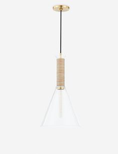 a glass and brass pendant light hanging from a ceiling fixture with a black cord attached to it