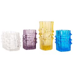 four different colored glass vases sitting next to each other