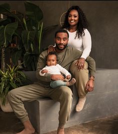 a man and woman sitting on a bench with a baby