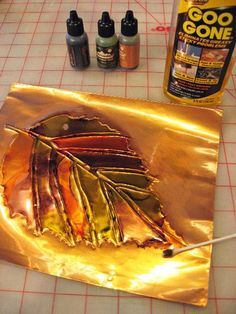 gold foil is being used to make an art project with acrylic paint and glue