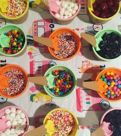 there are many ice creams and desserts in bowls on the table with spoons