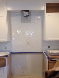 a kitchen with white cabinets and blue tape on the counter tops, in front of an oven