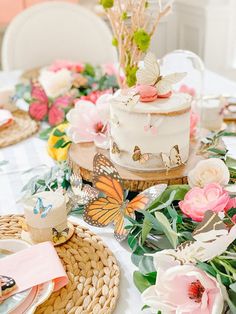 a table topped with a white cake covered in flowers