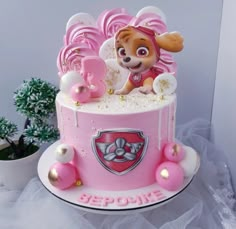 a pink and white cake with a dog in the middle on it's side