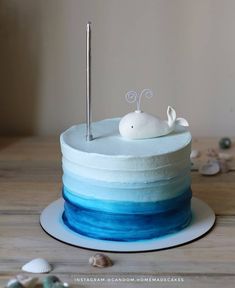 a blue and white ombrella cake with a small bird on top